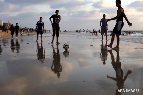 Palestinians enjoy playing the football in the sea at Gaza beach on July 9, 2013. ahead of the Muslim holy fasting month Ramadan. Photo by Ashraf Amra