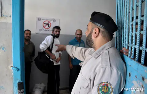 Palestinian prisoners wait to leave the prison run by the security forces in Gaza Strip, in Gaza City on July 10, 2013 Security officials in Gaza Strip said on Wednesday they released 65 criminal prisoners occasion of th...