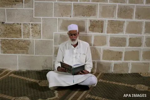 A Palestinian man reads verses from the Koran, Islam's holy book, at al-Omari mosque on the first day of the Muslim fasting month of Ramadan on July 10, 2013 in Gaza City. During Ramadan, one of the five main religious o...