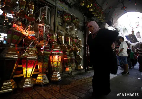 Palestinians walk in an illuminated street during the first day of the holy fasting month of Ramadan, in Jerusalem on July 10, 2013. Photo by Saeed Qaq