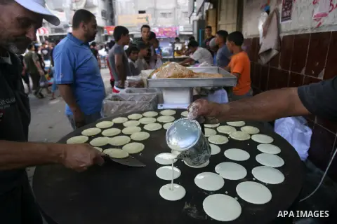 A Palestinian vendor prepares traditional pancakes known as ''Qatayef'' on the second day of the Muslim fasting month of Ramadan on July 11, 2013 in Rafah in southern Gaza strip. During Ramadan, one of the five main reli...