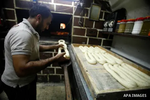 A Palestinian man bakes traditional bread during the holy month of Ramadan in Jerusalem's old city, 12 July 2013. Muslims around the world are observing the holy fasting month of Ramadan in which they refrain from eating...