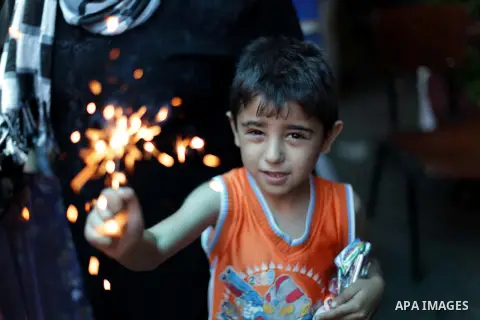 A Palestinian boy plays with fireworks on the fourth day of the Muslim fasting month of Ramadan on July 13, 2013 in Gaza city. During Ramadan, one of the five main religious obligations under Islam, Muslims are required...