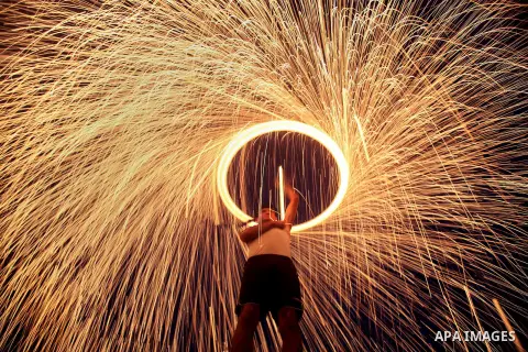 A Palestinian man plays with fireworks celebrating the holy fasting month of Ramadan in Gaza city on July 13, 2013. During Ramadan, one of the five main religious obligations under Islam, Muslims are required to abstain...
