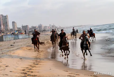 Palestinians enjoy riding a horse in the sea at Gaza beach in Gaza city, July 14, 2013. Photo by Mohammed Asad