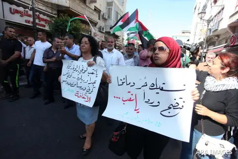 Palestinian protesters hold placards during a demonstration against Israeli government's plans to relocate Bedouins in the Negev desert, on July 15, 2013 near the West Bank town of Ramallah. Thousands of Bedouins demonst...