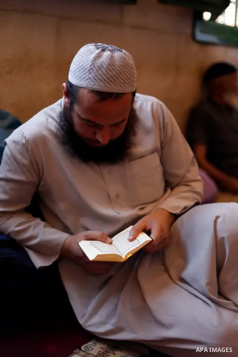 A Palestinian man reads holy Quran at al-Aqsa mosque during the holy fasting month of Ramadan, in Jerusalem's old city on July 15, 2013. During Ramadan, muslims around the world are observing the holy fasting month of Ra...