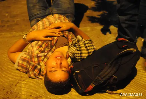 A supporter of deposed Egyptian President Mohamed Mursi who was wounded by rubber bullets and affected by tear gas reacts during clashes with riot police on the Sixth of October Bridge over the Ramsis square area in cent...
