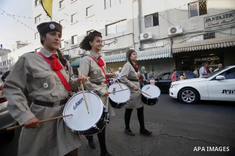 Palestinian scouts play musical instruments as they parade through the streets during a celebrate the holy month of Ramadan in the Jerusalem old city, on July 16, 2013. Muslims around the world are observing the holy fas...