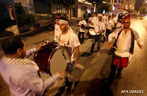 Palestinian dawn awakeners, al-Musaharati in Arabic, walk through streets to wake up Muslims for a meal before sunrise during the fasting month of Ramadan, in the West Bank city of Hebron city on July 18, 2013. Al-Musaha...