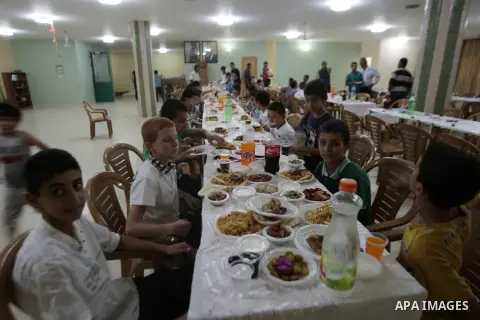 Palestinian poor children break their fasting during Iftar ceremony organized by the Zakat committee, during the holy fasting month of Ramadan, in the West Bank village of Salem near Nablus, July 18, 2013. During Ramadan...