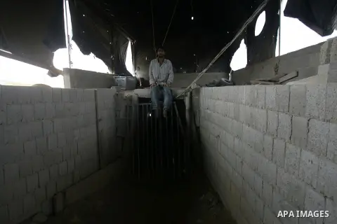 A Palestinian worker sits at the entrance of smuggling tunnels along the Gaza Strip's border with Egypt near the southern town of Rafah on July 19, 2013. The Egyptian authorities closed the Rafah border crossing with Gaz...