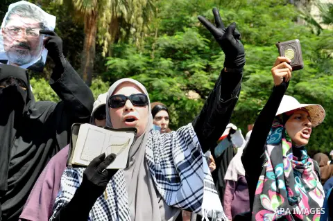 Supporters of ousted Egyptian President Mohammed Morsi march through the residential neighborhood of Garden City, passing several diplomatic missions, but avoiding the U.S. embassy, in Cairo, Egypt, Saturday, July 21, 20...