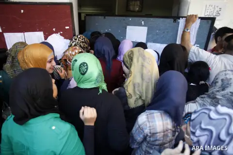 Palestinian students look for their names in the results of final high school exams, known as "Tawjihi" in Jerusalem on July 25, 2013. The Ministry of Education in Gaza Strip and the West Bank announced the results toget...