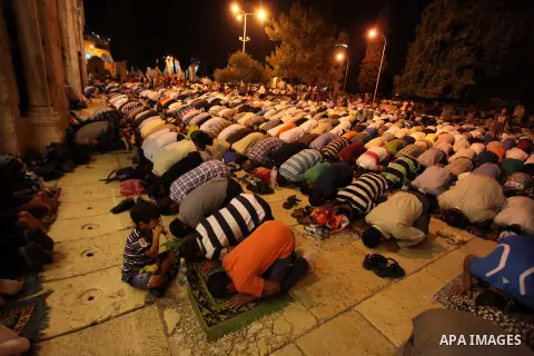 Palestinian Muslim men take part in an evening prayer in front of the Dome of the Rock at the Al-Aqsa mosque compound in the old city of Jerusalem during the fasting month of Ramadan on Aug. 02, 2013. Photo by Issam Rima...