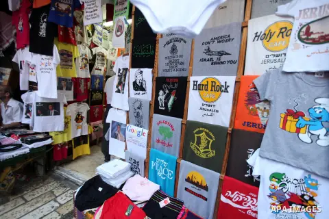 A Palestinian man sells clothes in front of Damascus gate during Muslim fasting month of Ramadan, in Jerusalem's old city, Aug 02, 2013. While fasting from dawn until sunset, Muslims refrain from consuming food, drinking...