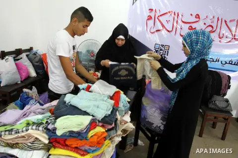 Palestinian youths sort and package clothes before distribute to the needy and poor on the occasion of the holy fasting month of Ramadan, in Gaza city, Aug 04, 2013. Throughout the month, devout Muslims must abstain from...