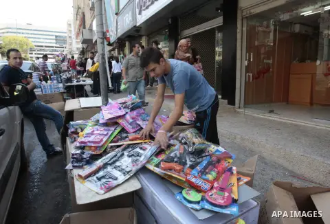 A Palestinian man sells toys at a street market during preparations for the upcoming Eid al-Fitr festival which is celebrated at the end of holy fasting month of Ramadan, in the West Bank city of Nablus Aug 06, 2013, as...