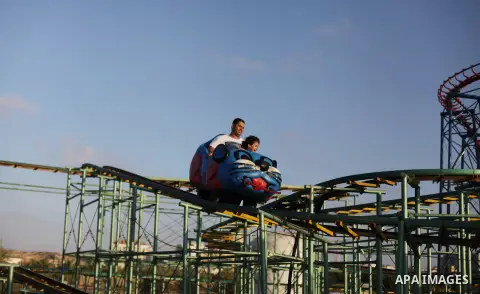 Palestinians enjoy a ride in an amusement park on the third day of Eid al-Fitr, marking the end of Islam's fasting holy month of Ramadan, in Gaza City on August 10, 2013. Photo by Ashraf Amra