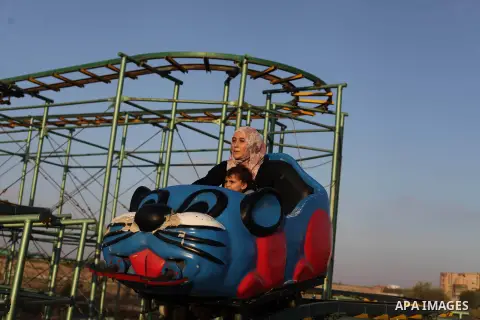 Palestinians enjoy a ride in an amusement park on the third day of Eid al-Fitr, marking the end of Islam's fasting holy month of Ramadan, in Gaza City on August 10, 2013. Photo by Ashraf Amra