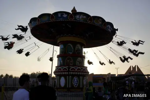 Palestinians enjoy a ride in an amusement park on the third day of Eid al-Fitr, marking the end of Islam's fasting holy month of Ramadan, in Gaza City on August 10, 2013. Photo by Ashraf Amra