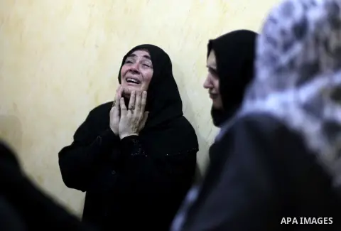 Palestinian relatives mourn the death of Hussein Awadullah in the Nusairat refugee camp, central Gaza Strip, on August 11, 2013. Israeli troops shot a Palestinian dead on the border with Gaza on the night of August 10, t...