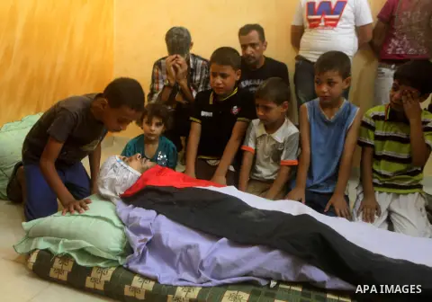 Palestinian mourners gather around the body of Hussein Awadullah, 32, during his funeral in Gaza City on Aug. 11, 2013. Awadullah was killed in an Israeli operation on the border with Gaza on Saturday night. Photo by Ash...