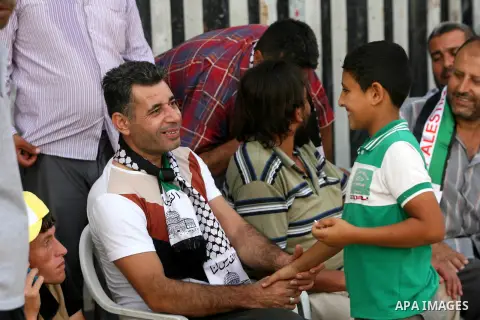 Freed Palestinian prisoner Midhat Barbakh shakes hands with a relative boy at his family's house in Khan Younis in the southern Gaza Strip August 14, 2013. Israel freed 26 Palestinian prisoners on Wednesday to keep U.S.-...