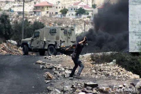 A Palestinian protester throws stones at Israeli security forces during clashes following a protest against the expropriation of Palestinian land by Israel in the village of Kfar Qaddum, near Nablus in the occupied West...
