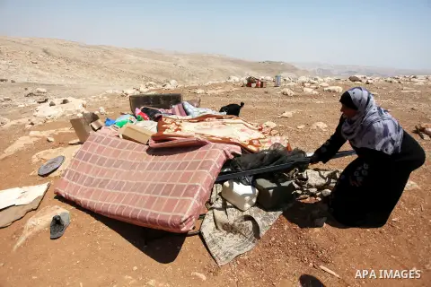 A Palestinian Bedouin woman searches in the rubble of her damaged tent after it was dismantled by Israeli bulldozers under the pretext of building without permits at al-Baq'a camp near the West Bank city of Jericho, Aug...