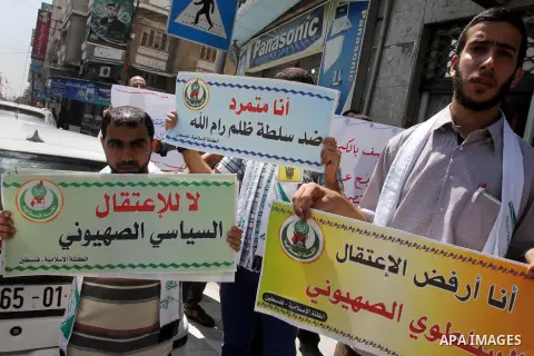 Palestinians hold banners during a protest calling for stop against members of Hamas violence by Ramallah government, in Gaza city on Aug. 22, 2013. Photo by Mohammed Asad