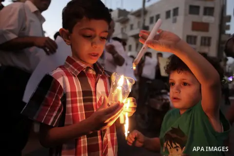 Palestinian boys hold candles during a vigil to show solidarity with Syrian civilians after hundreds were killed on Wednesday in rebel-held Damascus suburbs, in the West Bank city of Ramallah August 22, 2013. Some 30 Pal...