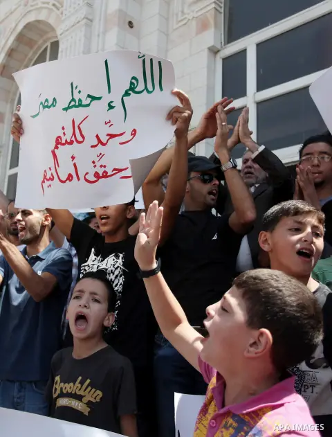 Palestinians raise their hands and four fingers, a sign that protesters say symbolizes the Rabaah al-Adawiya mosque in Cairo that was cleared last week by Egyptian security forces, during a rally in support of the ousted...