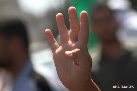 A Palestinian holds up four fingers, a sign that protesters say symbolizes the Rabaah al-Adawiya mosque in Cairo during a protest against Palestinian-Israeli negotiations, and supporting Egypt's ousted President Mohammed...