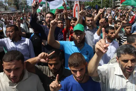 Palestinian supporters of Hamas and Islamic Jehad hold national flags during a protest against Palestinian-Israeli negotiations on August 23, 2013, in Gaza City. A senior Palestinian official accused on August 23 Israel...