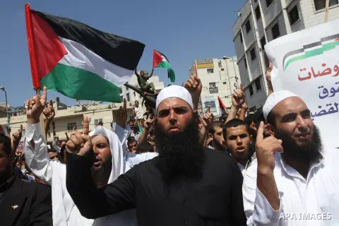 Palestinian supporters of Hamas and Islamic Jehad hold national flags during a protest against Palestinian-Israeli negotiations on August 23, 2013, in Gaza City. A senior Palestinian official accused on August 23 Israel...