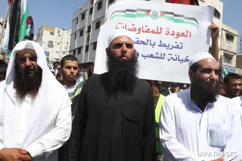 Palestinian supporters of Hamas and Islamic Jehad hold national flags during a protest against Palestinian-Israeli negotiations on August 23, 2013, in Gaza City. A senior Palestinian official accused on August 23 Israel...