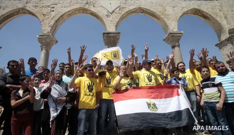 Palestinian supporters of the radical Islamist movement Hamas raise their hands and four fingers, a sign that protesters say symbolizes the Rabaah al-Adawiya mosque in Cairo that was cleared last week by Egyptian securit...