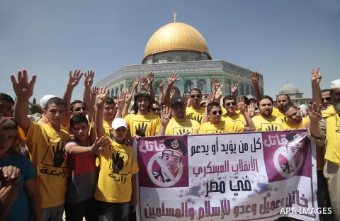 Palestinian supporters of the radical Islamist movement Hamas raise their hands and four fingers, a sign that protesters say symbolizes the Rabaah al-Adawiya mosque in Cairo that was cleared last week by Egyptian securit...