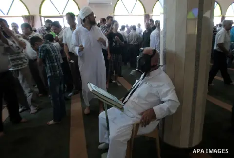 Palestinian worshipers cover their faces after inhaling tear gas fired by Israeli security forces at a mosque during Friday prayer in the village of Kfar Qaddum, near Nablus in the occupied West Bank on August 13, 2013....