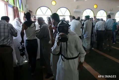 Palestinian worshipers cover their faces after inhaling tear gas fired by Israeli security forces at a mosque during Friday prayer in the village of Kfar Qaddum, near Nablus in the occupied West Bank on August 13, 2013....
