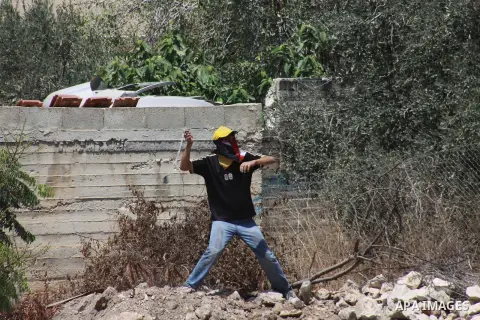 A Palestinian protester throws stones at Israeli security forces during clashes following a protest against the expropriation of Palestinian land by Israel in the village of Kfar Qaddum, near Nablus in the occupied West...