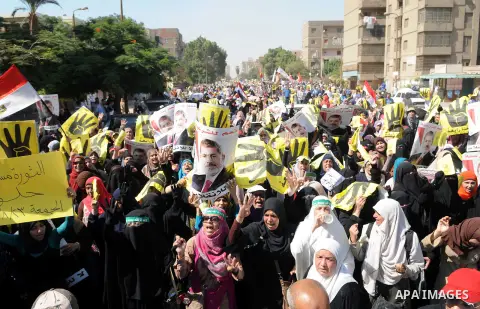 Egyptians supporters of ousted president Morsi hold posters depicting him and others depicting a hand in a sign of the number four during a Friday protest called for by the Muslim Brotherhood in Helwan, Egypt, 23 August...