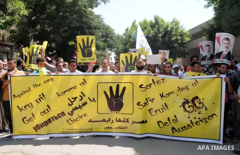 Egyptians supporters of ousted president Morsi hold posters depicting him and others depicting a hand in a sign of the number four during a Friday protest called for by the Muslim Brotherhood in Helwan, Egypt, 23 August...