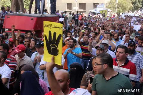 Egyptians supporters of ousted president Morsi hold posters depicting him and others depicting a hand in a sign of the number four during a Friday protest called for by the Muslim Brotherhood outside al-Aziz Bellah Mosqu...
