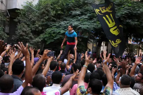 Egyptians supporters of ousted president Morsi hold posters depicting him and others depicting a hand in a sign of the number four during a Friday protest called for by the Muslim Brotherhood outside al-Aziz Bellah Mosqu...