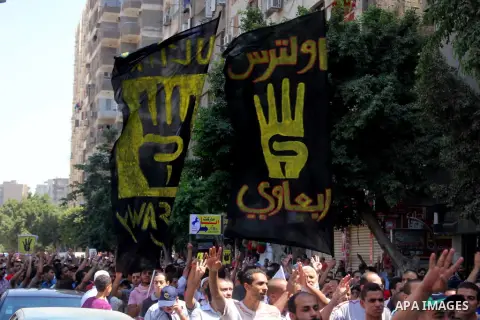 Egyptians supporters of ousted president Morsi hold posters depicting him and others depicting a hand in a sign of the number four during a Friday protest called for by the Muslim Brotherhood outside al-Aziz Bellah Mosqu...