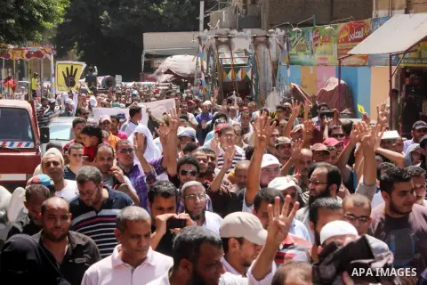 Egyptians supporters of ousted president Morsi hold posters depicting him and others depicting a hand in a sign of the number four during a Friday protest called for by the Muslim Brotherhood outside al-Aziz Bellah Mosqu...