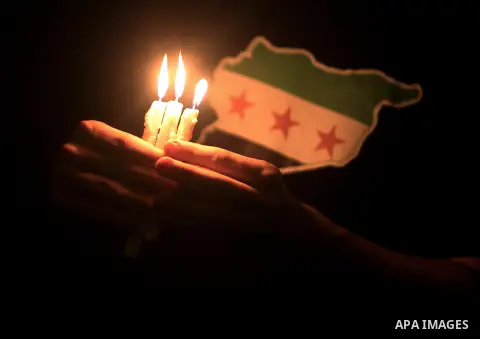 A Palestinian man holds lit candles during a protest against Syria's President Bashar al-Assad in front of the U.N. headquarters in Gaza City August 23, 2013. U.N. Secretary-General Ban Ki-moon said on Friday he intends...