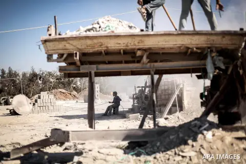 Palestinian laborers work on a crusher machine at a brick factory in center Gaza Strip, Aug 22, 2013. Palestinians re-use old bricks in construction after the Egyptian army started to knock down Gaza smuggling tunnels la...